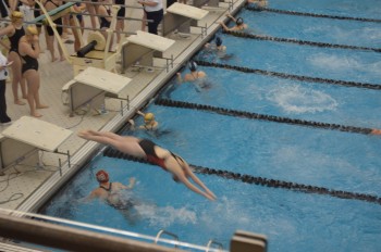 Senior Katie Norris dives into the pool during the girls relay event. Photo By: Barb Kroner 