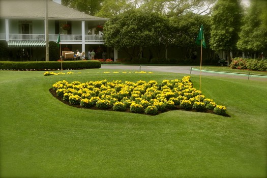 The flower bed in the shape of the masters logo sits infront of the clubhouse at Augusta National.  Photo By: pocketwiley at wikimedia.com