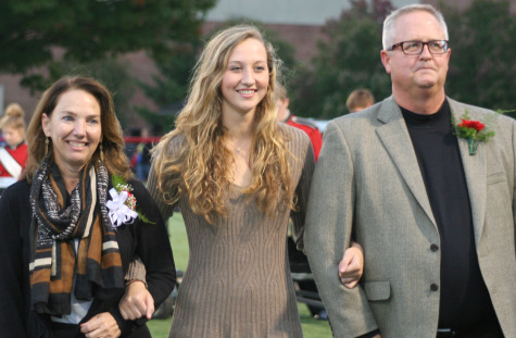 Homecoming court nominee Abigail Bentz walks the field with her parents, Paul and Karole Bentz. Photo by Kerrie DeFelice.