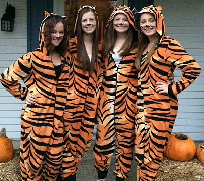 Freshmen Taylor Stenley, Kelly Porter, 
Emma DeLuca, and Amber Bornter strutted in their tiger onesies as they went trick or treating. Photo by Kelly Porter.  