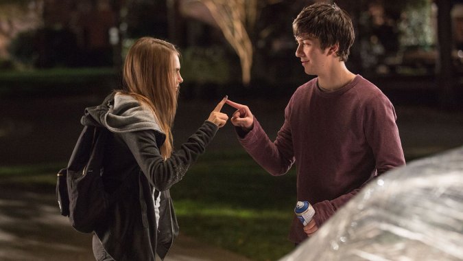 Cara Delevingne and Nat Wolff share some sort of John Green cutesy touch in a promotional still from Paper Towns. Courtesy 20th Century Fox.