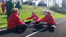 Members of the 4x8 relay team stretch before their event.
Photo By: Courtney Rodgers