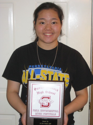 Kristen Zak holding an award she received during her time at the PMEA festivals.