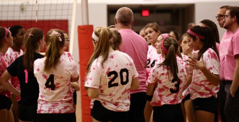 The girls' volleyball team huddles up in their Dig Pink game for Breast Cancer research. Courtesy of Robert DeFelice.