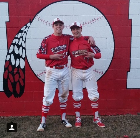 Senior Aaron Portner poses with junior Connor Hood against the newly painted dugout. Photo courtesy of Connor Hood via Instagram.
