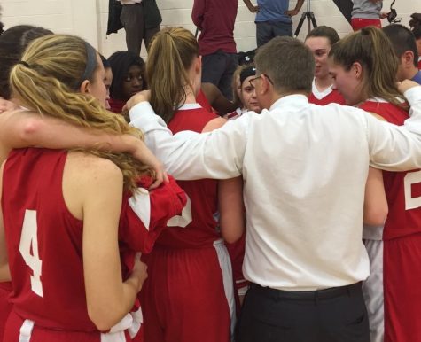 Girls basketball huddles during a timeout