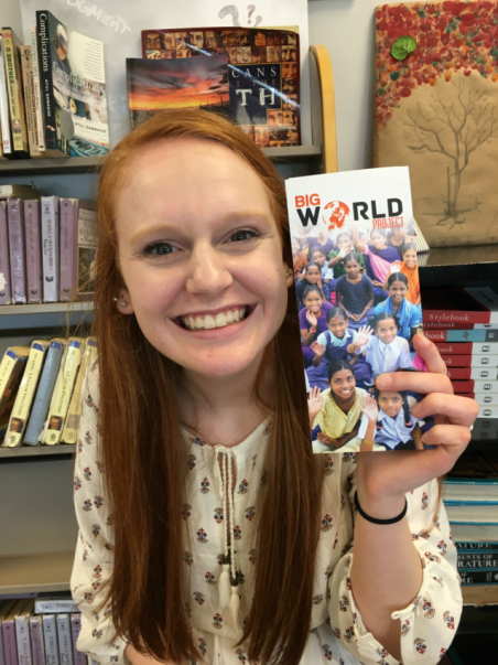 Junior Emily Rivers, who was present at Steve Pettits speech, poses with a Big World Project pamphlet.
