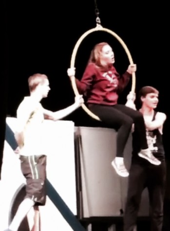 Sophomore Julia Twaddle (center), who plays Berthe, performs several stunts on a ring, assisted by senior Ryan Denis (left) and sophomore Kaleb Fair (right).