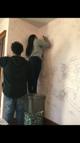 Photo of Jackson outlining her wall with the help of her brother senior Khalil Jackson Photo By:Allure Sapp