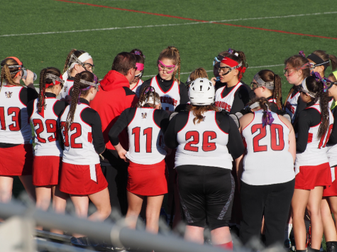 The team huddles on the field. Photo by Lisa Miller.