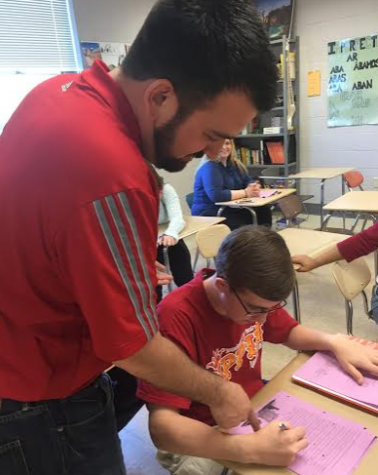 Spanish teacher Nick Schiffgens assists sophomore Justin Feild with an assignment. Photo by Karly Matthews.