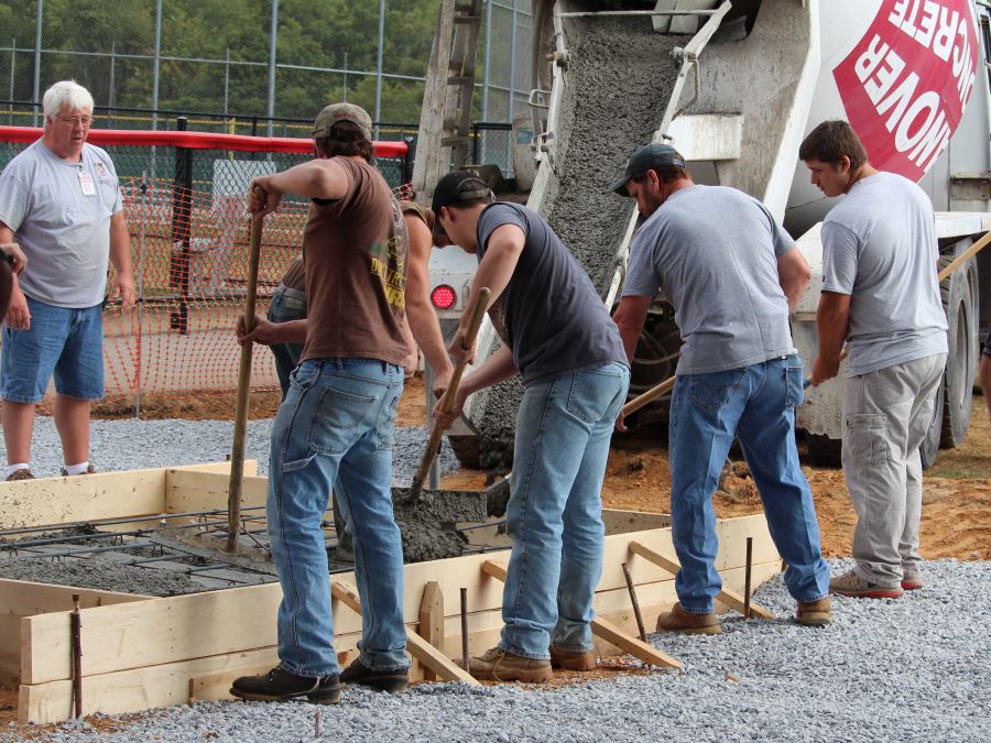 Susquehannock High School construction students pour concrete for the new ticket booth.