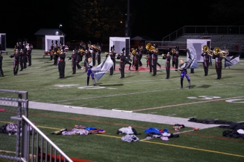 The color guard and band perform together. 
