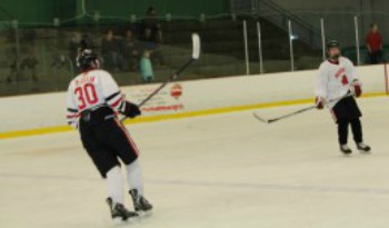 Warrior players wait for the puck to come their way.