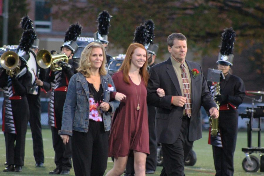 Senior Erin Kaliszak walks with her mother and father before she finds out she has been crowned homecoming queen. 