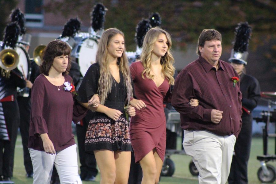 Seniors Harley and Hannah Mummert walk with their mother and father. 