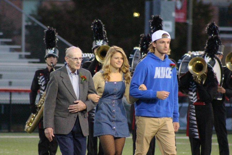 Senior Taylor Tannura walks with her grandfather and brother for Homecoming court.  