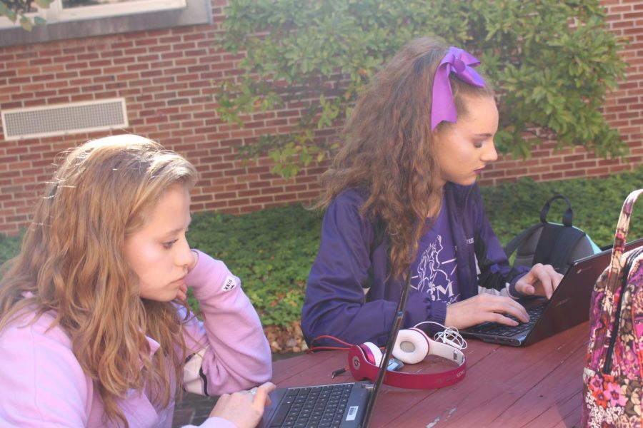 [From left to right] Sophomores Caroline Kinna and Emma Williams work in the courtyard.Photo by Chris Norris