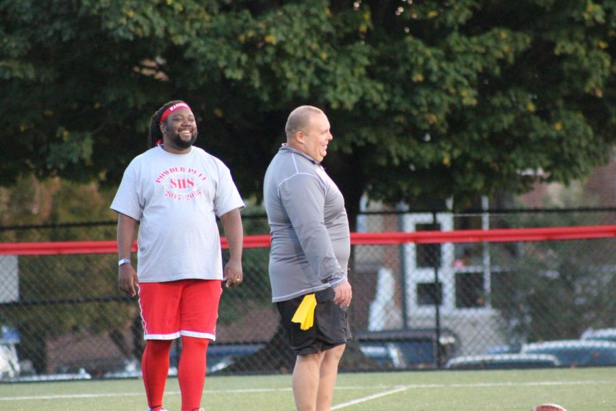 Matthew Shervington and Kevin Molin smiling while  coaching the powderpuff game. 