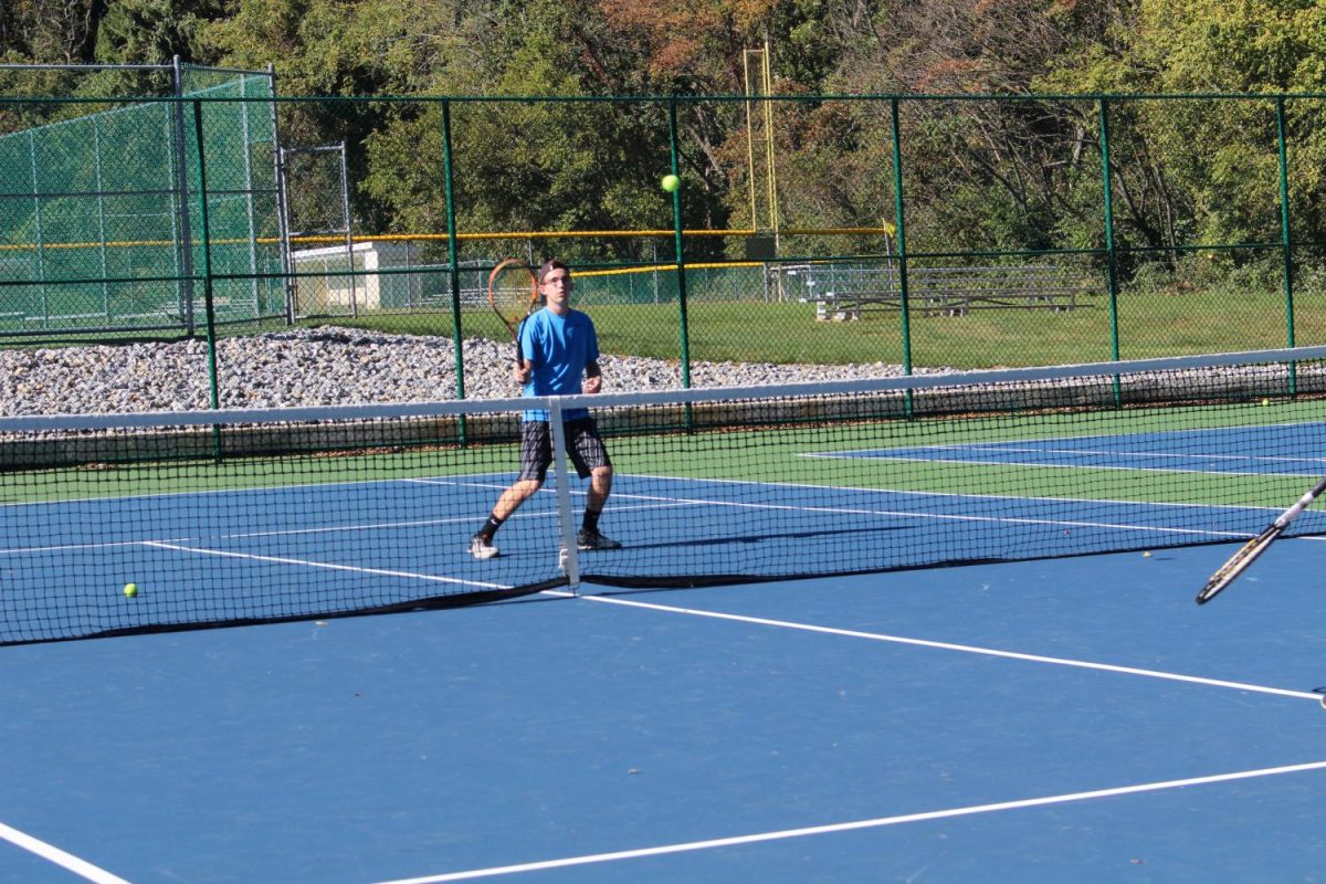 Senior Justin Field prepares to hit the tennis ball served to him