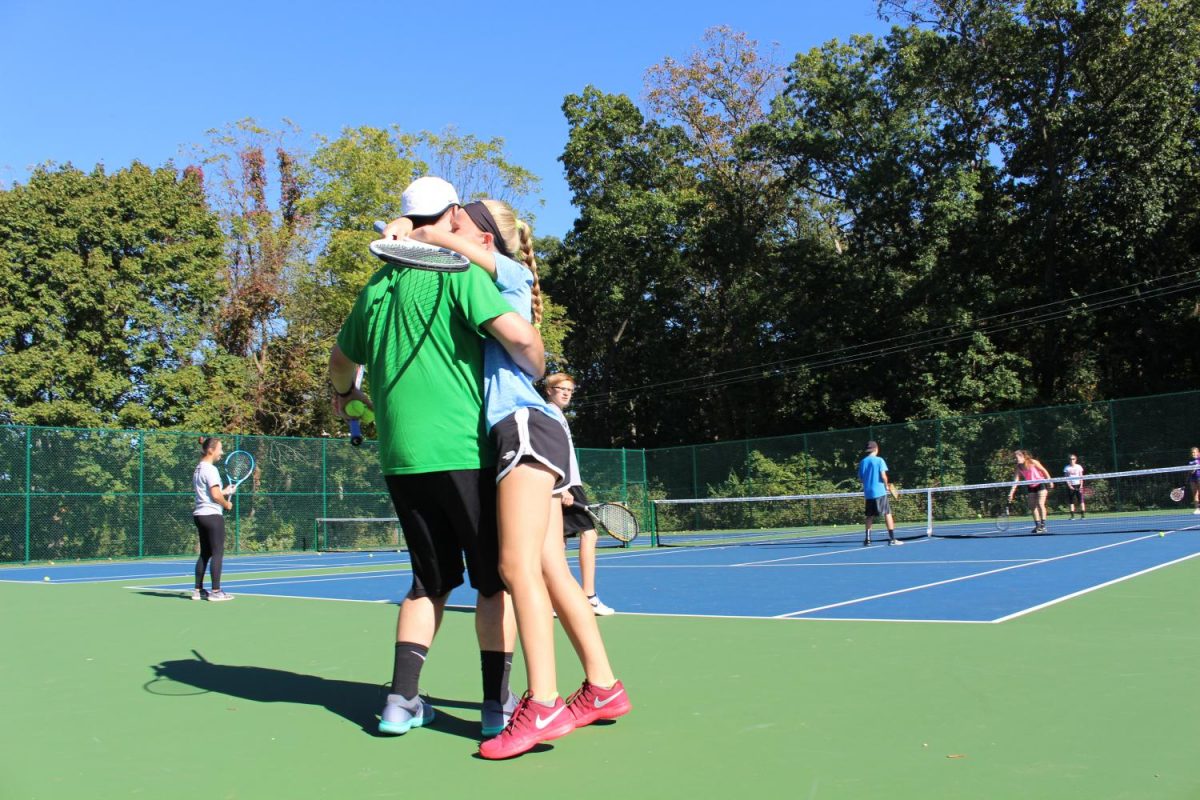 Junior Julianne Cassady greets assistant coach Austin Scott to the court. Photo by: Jade Reall 