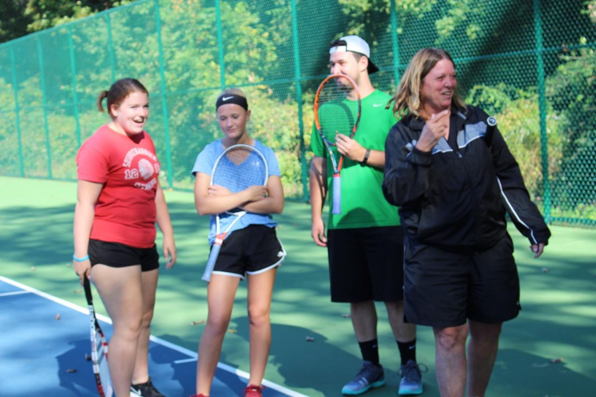 Coach Marianne  Michels (right) laughs with senior Molly Hogan (left), coach Austin Scott (right center) , and freshman Kaitlyn Endres (left center. Photo by: Jade Reall )