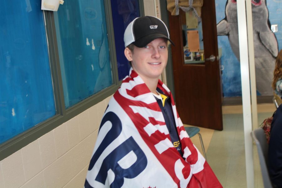 Senior Landon Lopez wraps a red, white, and blue sports flag around his shoulders during class. Photo by Christopher Norris