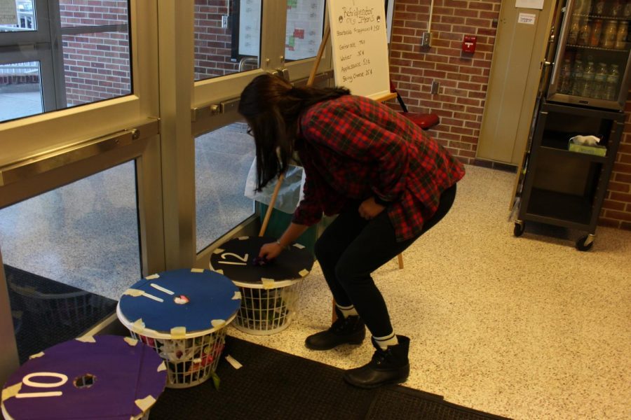 Senior Amaya Rutzel places the flower she found in the basket for her class. [Photo by Maggie Sisler]