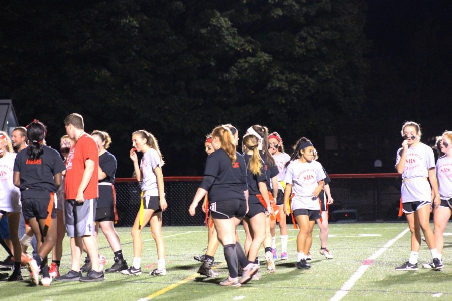 Juniors and seniors walk to their coaches to discuss a possible play. 