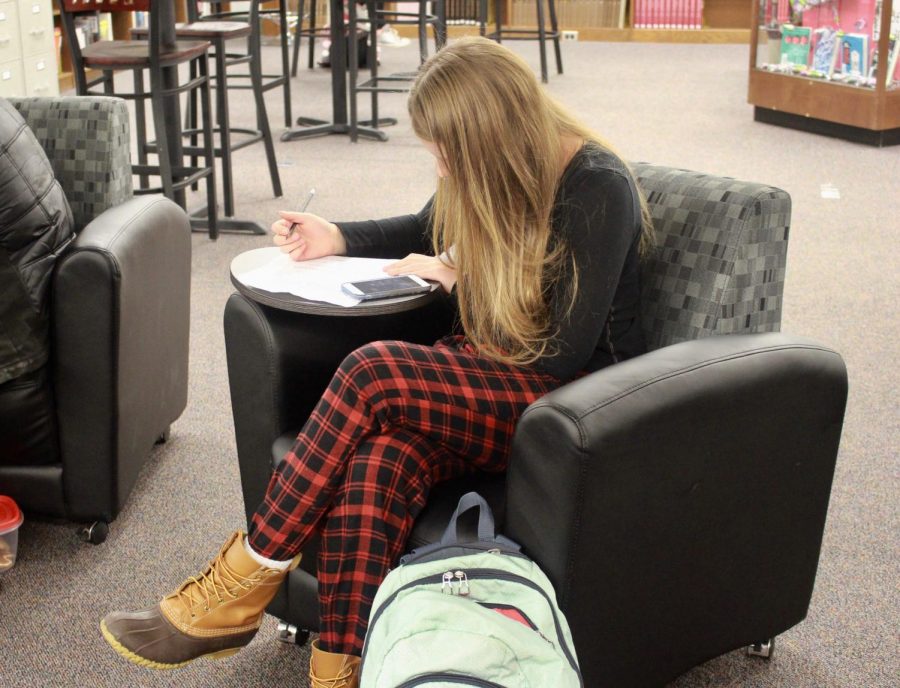This student works in the library on pajama day. 
