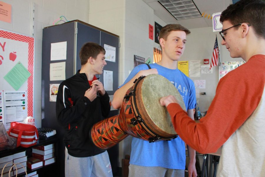 Alex Bongardt [center] brings in a drum to represent the ones used in the novel Things Fall Apart.