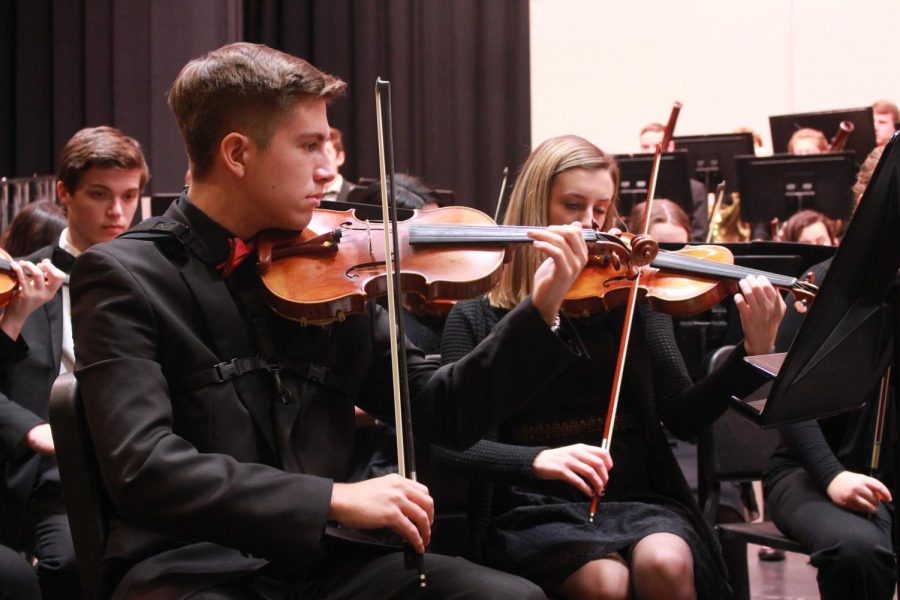 Orchesta members tune their instruments before the concert begins. 