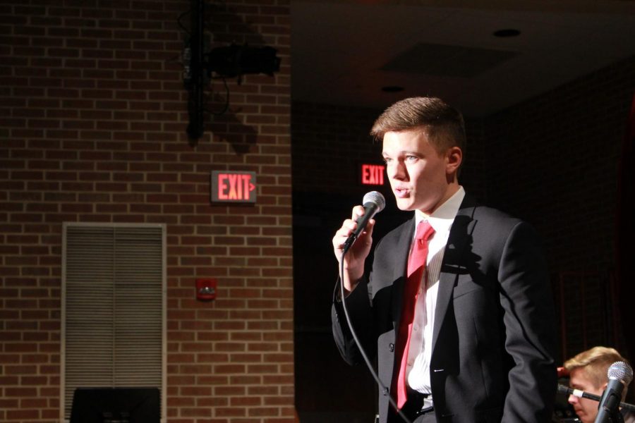 Senior Brendan Paules sings a holiday song with the jazz band during the concert. 