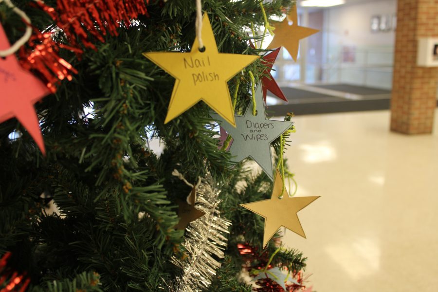 The giving tree stands in the auditorium lobby with ornaments to represent a gift that a student can bring in as a donation. 