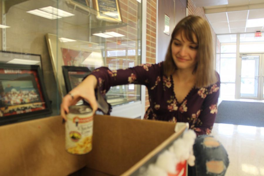 Senior Hannah Stambaugh places a can in one of the candidates boxes. Photo by: Brittany Boone