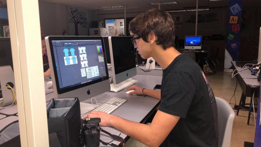 Senior Brady Mock works on a t-shirt design in his photo design independent study. His class is taught by Wade Bowers. Photo by Chris Norris.