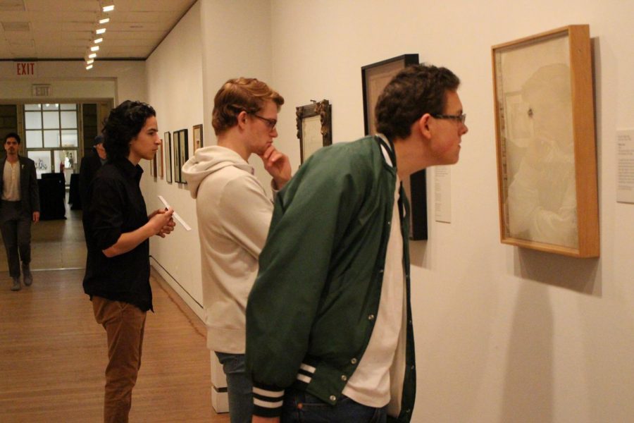Senior Hunter Davis, junior Matthew Sharkey, and sophomore David Wentzel each observe art pieces.