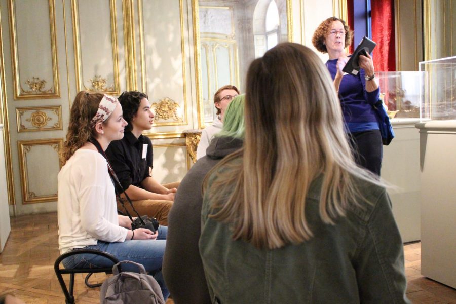 French students listen to the Tour Guide Diane as she describes the french artistry in the room.