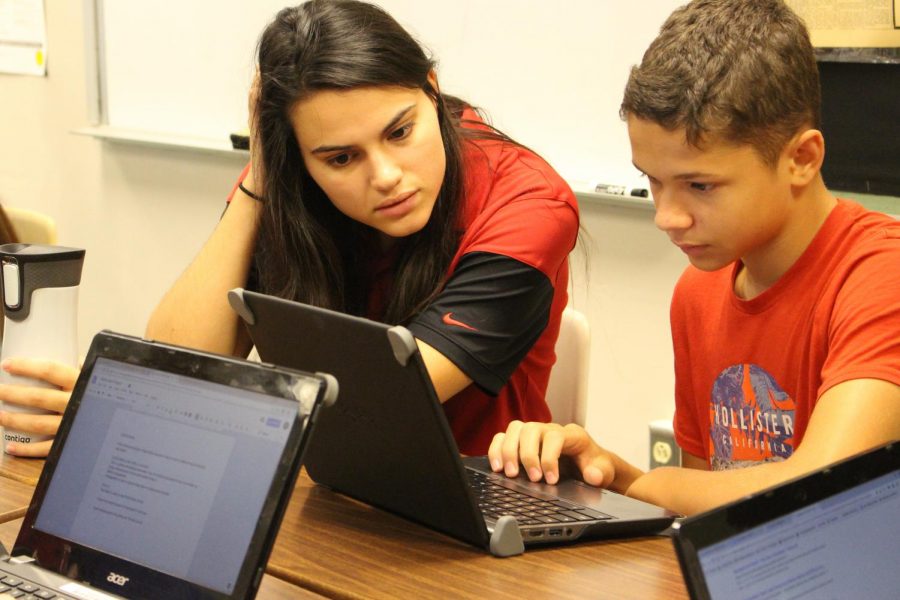 Social Studies teacher Abigail Shenot helps sophomore Jacob Derkosh with an assignment.