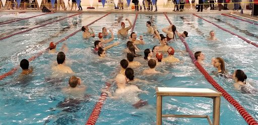 Some team members join in a chant, pumping their fists in the air to celebrate the ending of the meet.