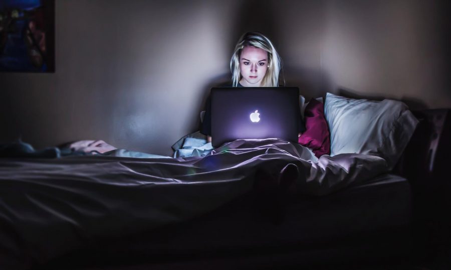 Woman siting in bed looking at a macbook.
Photo by Victoria Heath on Unsplash