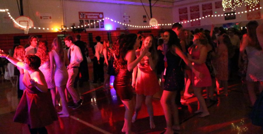 Students dance under the flashing colored lights. 
