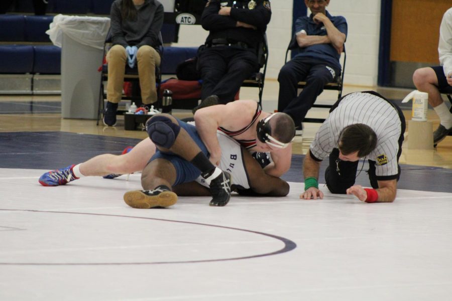 The referee watches closely as Romjue finishes off his opponent and captures his 100th victory. Photo by Mackenzie Womack.