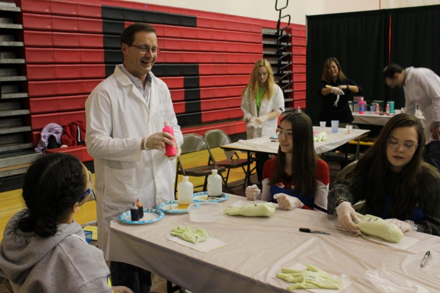 Chemistry presenter Eric Paules laughs with his group while making foam hands. He commented on the day, saying, “I think this was my 6th time doing the STEM Chemistry activity at SHS.  Its a fun day for me...working with the students, mixing chemicals, and making foam hands!”
Photograph by Ava Holloway
