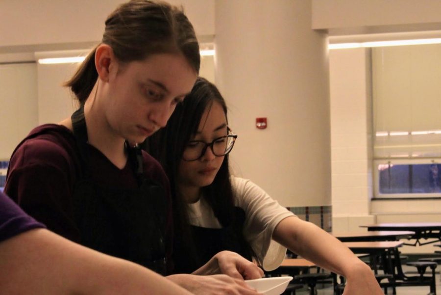 Theatre crew members junior Kaitlynn Ness and sophomore Tina Dao work hard preparing for the Paint Night. 