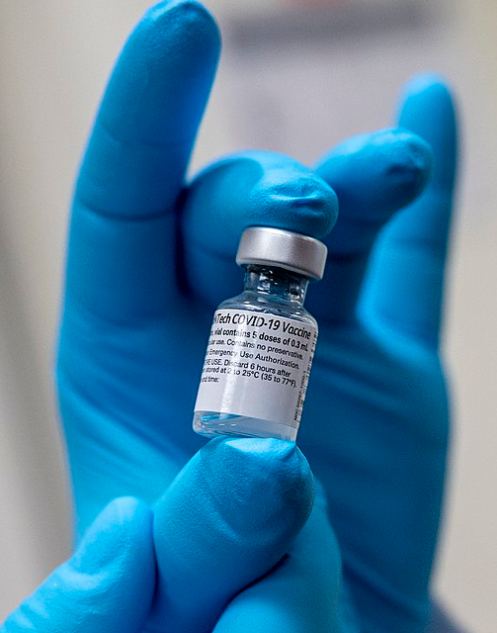 A doctor holds a vial of the BioNTech COVID-19 mRNA vaccine. Photo by U.S. Secretary of Defense, CC BY 2.0 <https://creativecommons.org/licenses/by/2.0>, via Wikimedia Commons