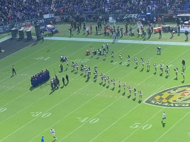 The Cheerleaders lead the Ravens team to midfield. When you go to a game there is so much noise you have to scream to have conversation with your family but it is electric being there and feeling the noise.