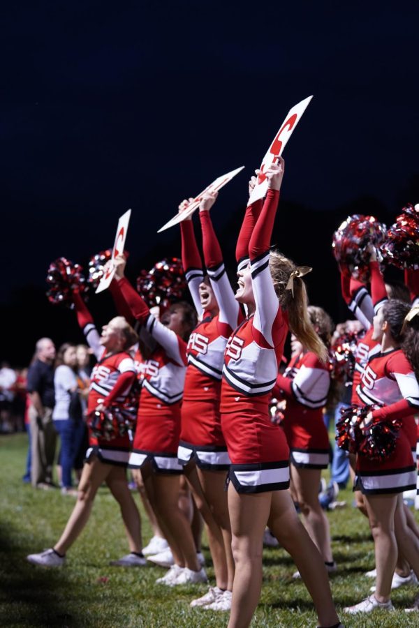 Cheerleaders engage the student section with signs and pom poms to get them excited about the game. Photograph by Naber Photography