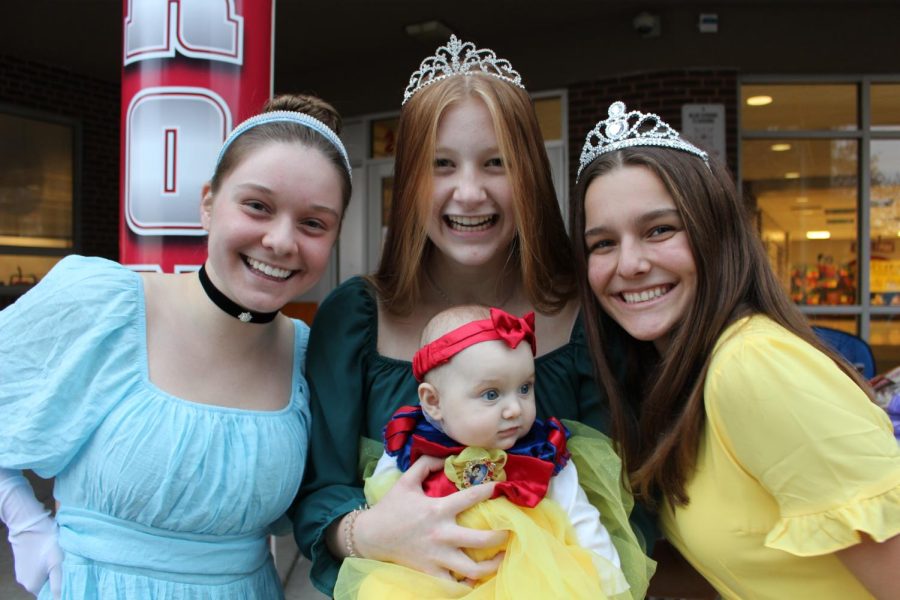 Kate Kalmanowicz, Madelyn Czahor, and Mackenzie Dryden pose with the daughter of English teacher Sara Mooney during October Fun Night on Oct. 26. 
“I really enjoyed seeing so many kids of our community come out to this event! I especially loved the creative costumes,” Kalmanowicz said. Photograph by Katie Ball