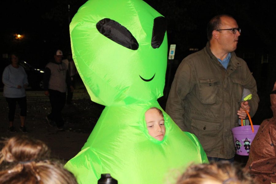 A boy in an inflatable alien costume waits in line to get candy from Class Councils table. Photograph by Katie Ball